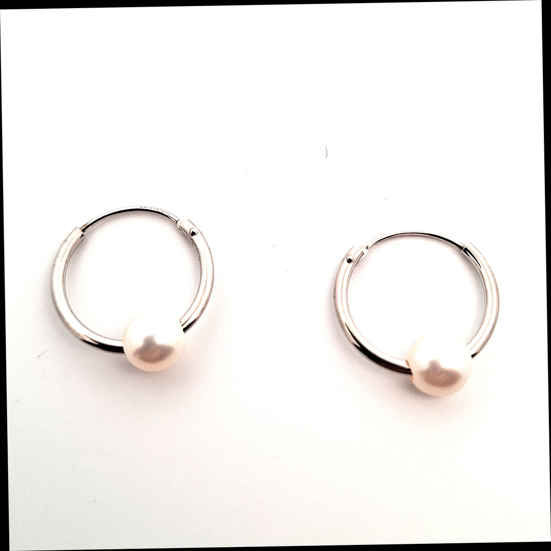 Pair of silver hoop earrings on a white background