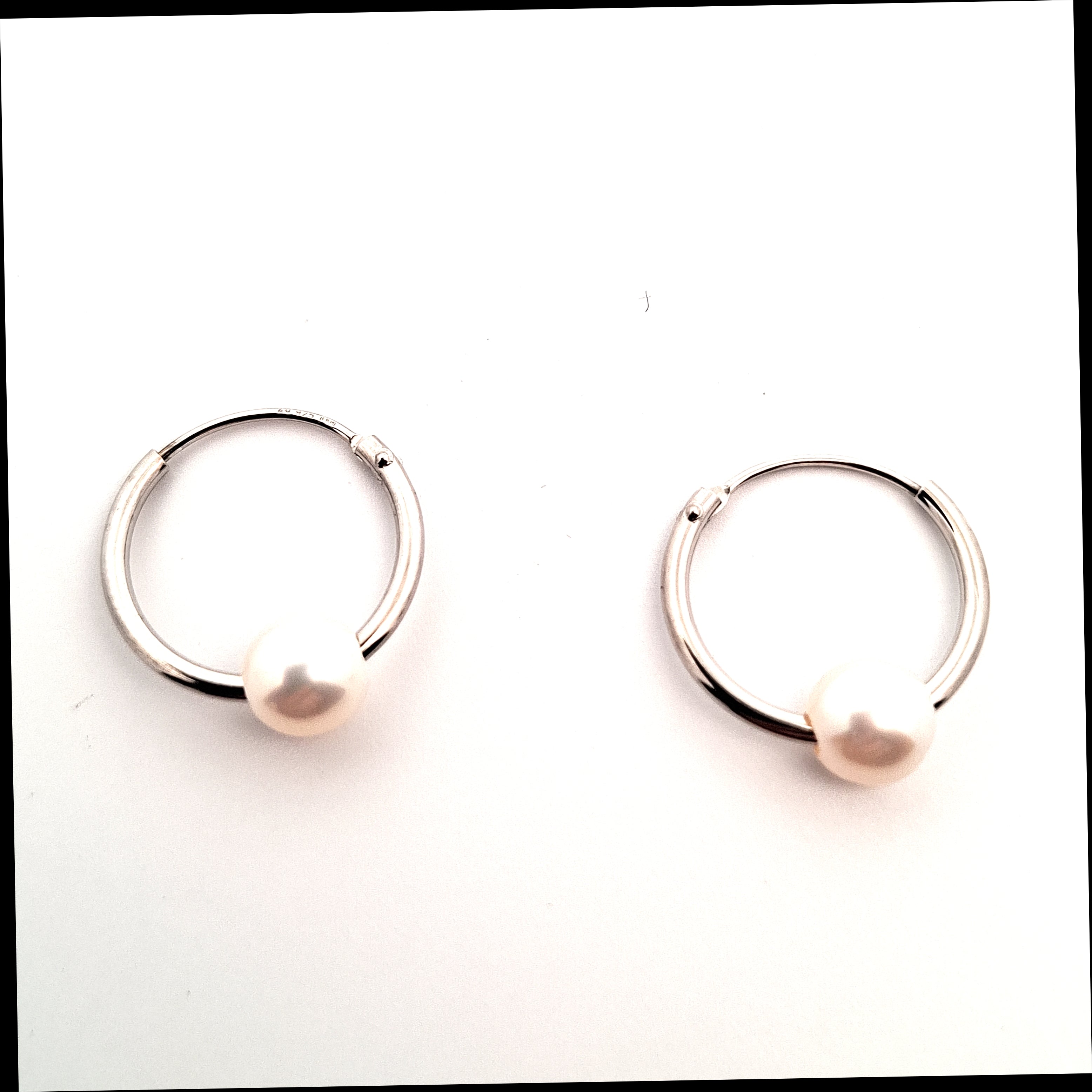Pair of silver hoop earrings on a white background