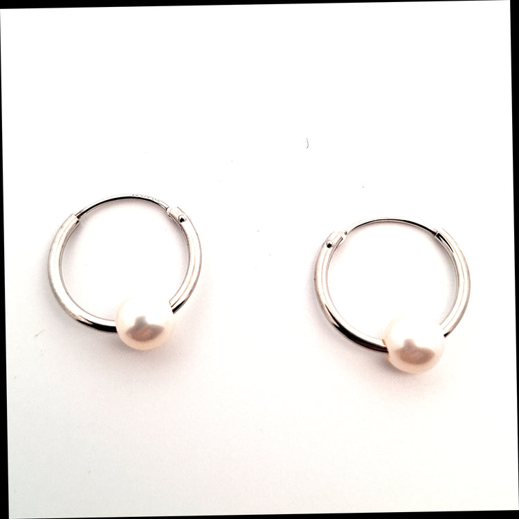 Pair of silver hoop earrings on a white background
