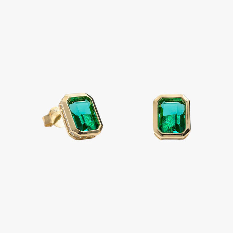 A pair of gold stud earrings featuring rectangular emerald-cut green gemstones, displayed on a clean, light gray background.