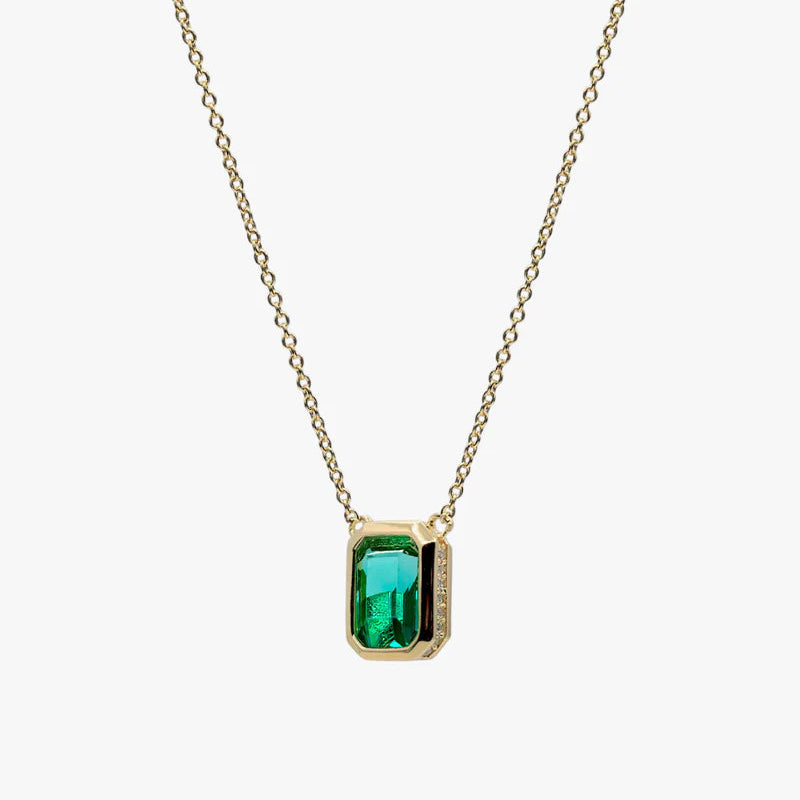 A gold chain necklace with a rectangular green gemstone pendant, shown against a plain light gray background.