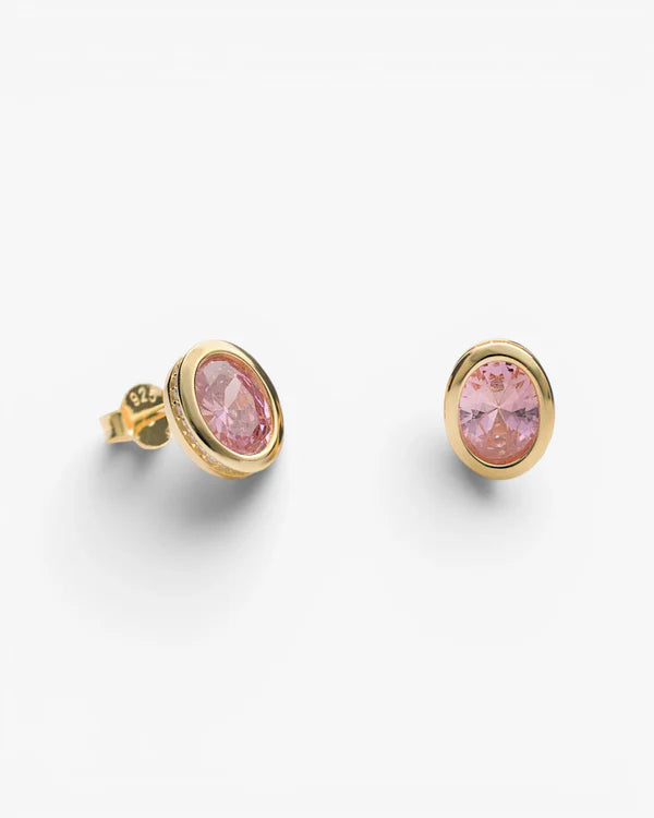 A pair of gold oval stud earrings with pink gemstones, shown on a clean white background.