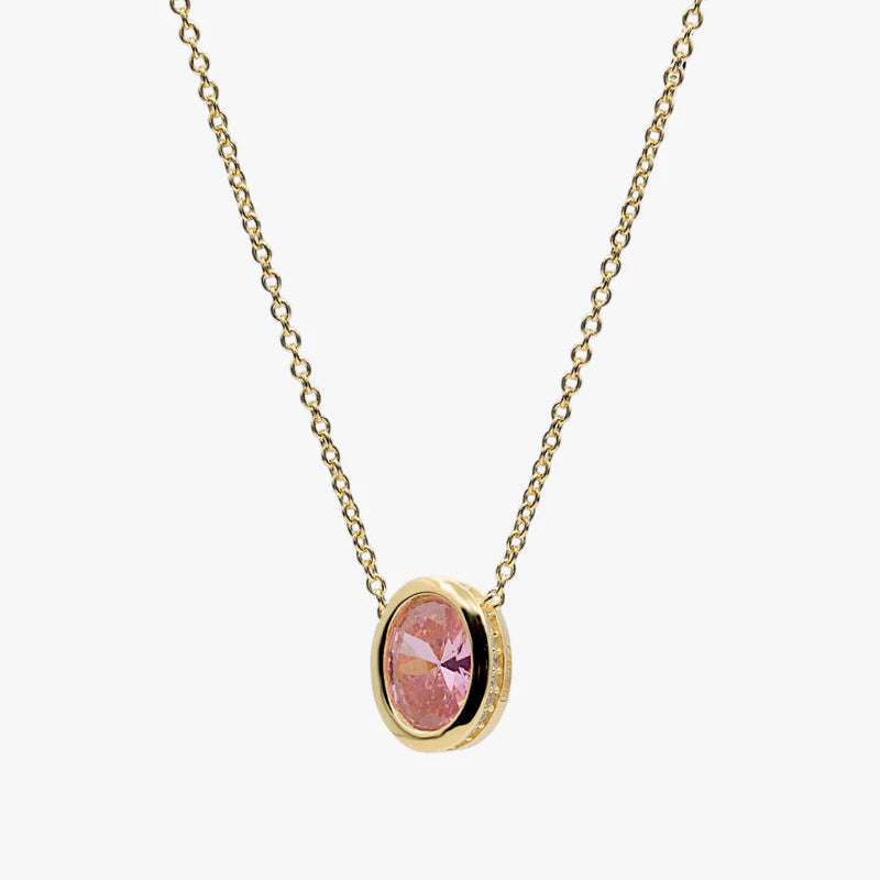 A delicate gold chain necklace with an oval pendant featuring a pink faceted gemstone in a gold bezel setting, shown against a plain light gray background.