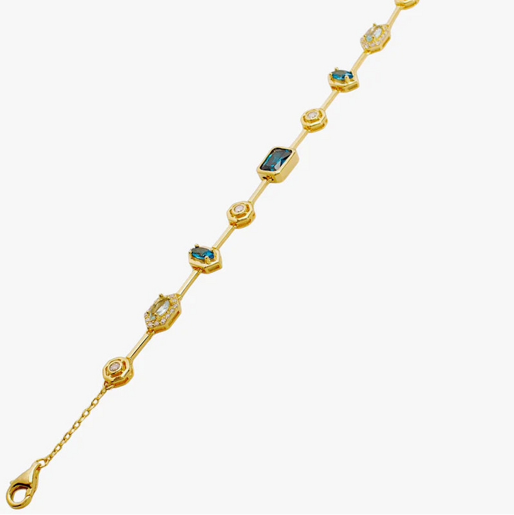 A gold chain bracelet featuring alternating round bezel-set clear stones and rectangular green gemstone 
