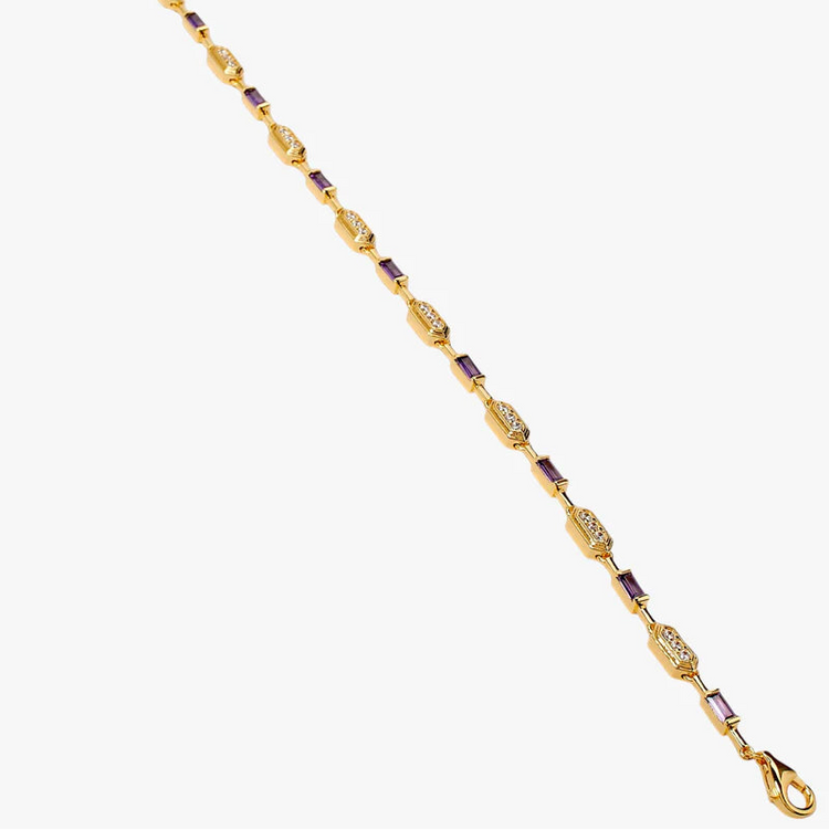 A gold-plated chain bracelet with alternating oval and elongated links, accented by small purple rectangular stones, shown on a plain light gray background.