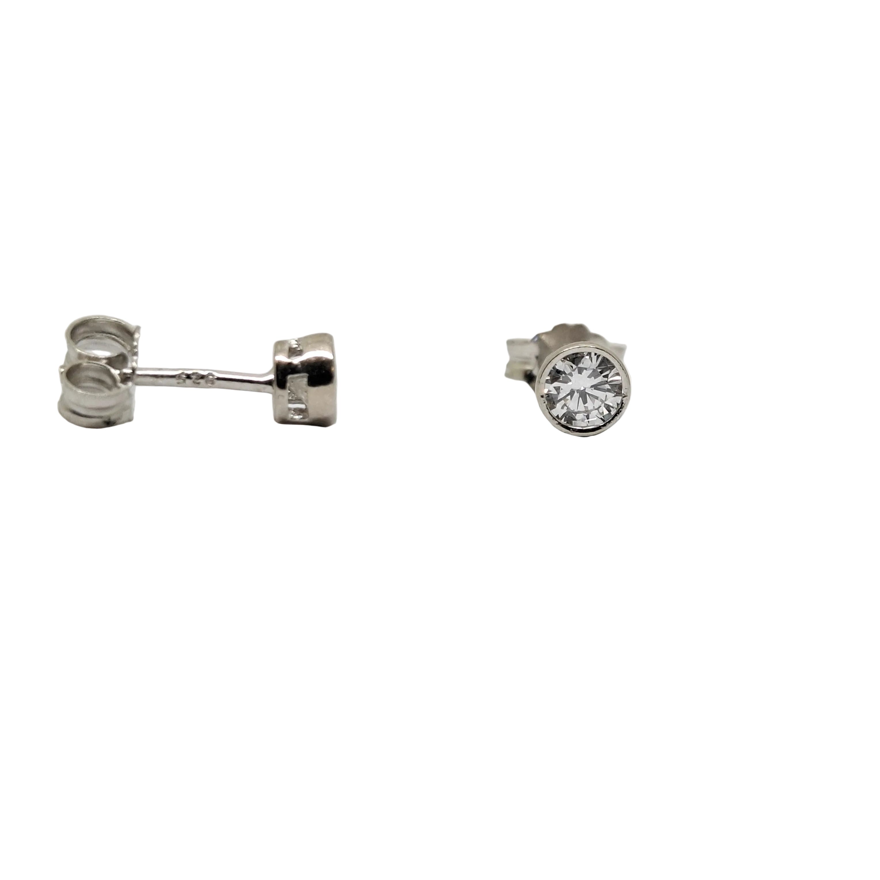 Pair of silver earrings with clear gemstones on a white background