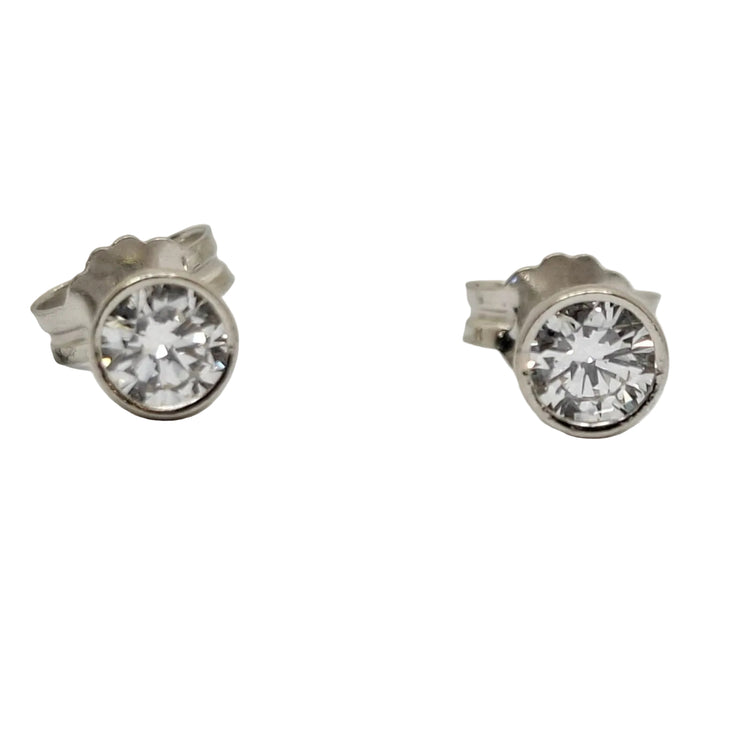 Pair of silver stud earrings with clear gemstones on a light gray background