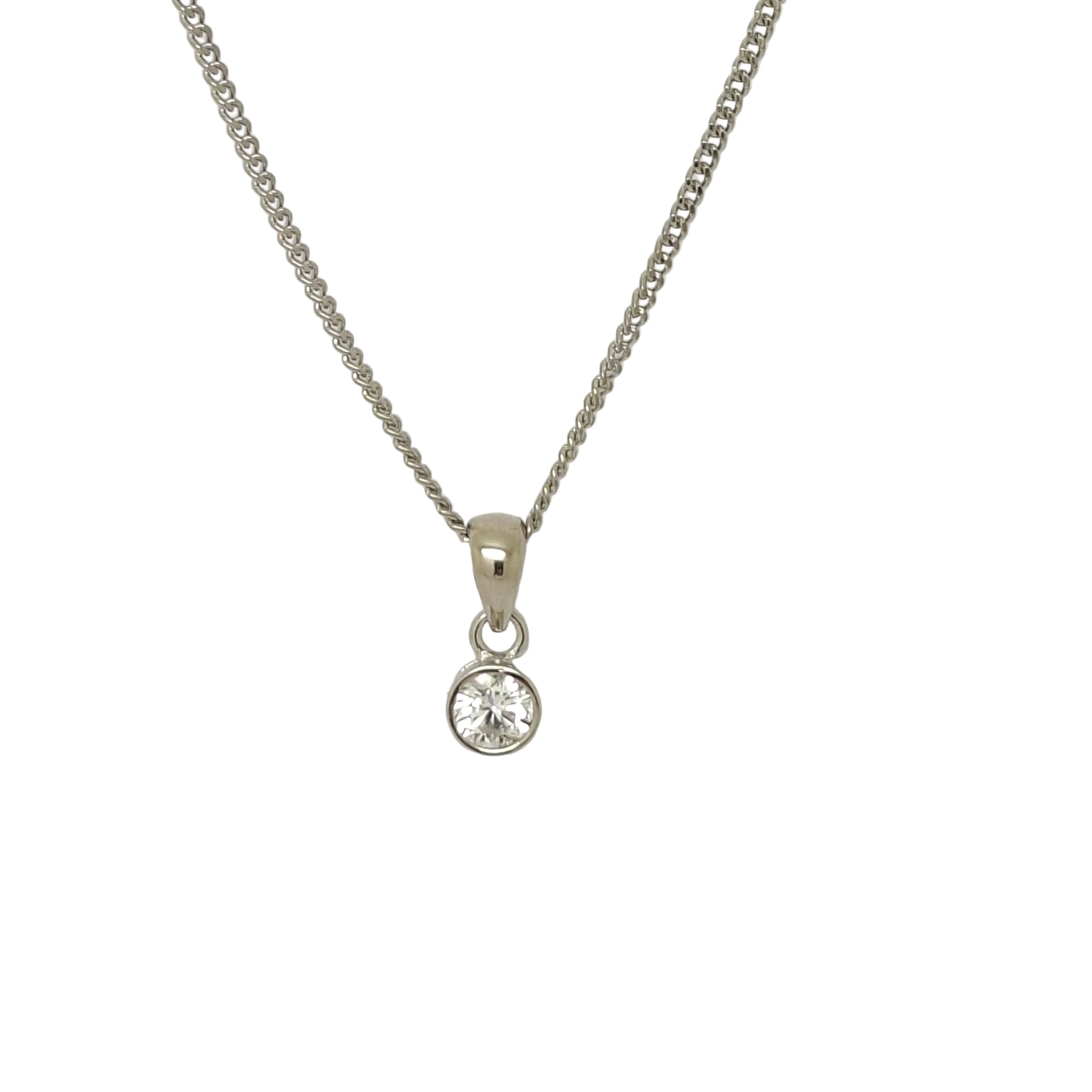 Silver necklace with a round pendant on a light gray background