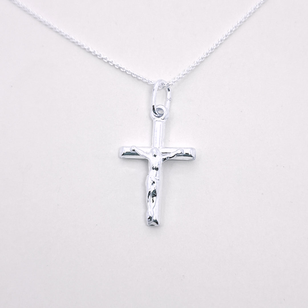 Silver cross pendant on a white background