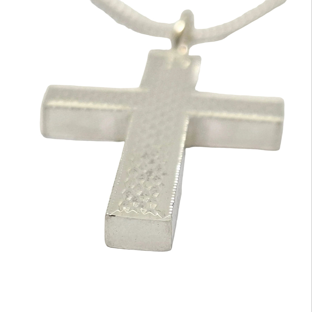 Silver cross pendant on a white background