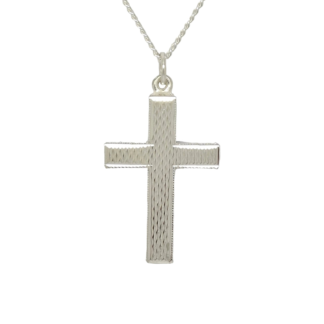 Silver cross pendant on a chain against a light gray background