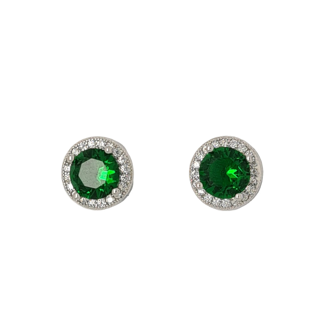 Pair of round earrings with green gemstones on a light gray background