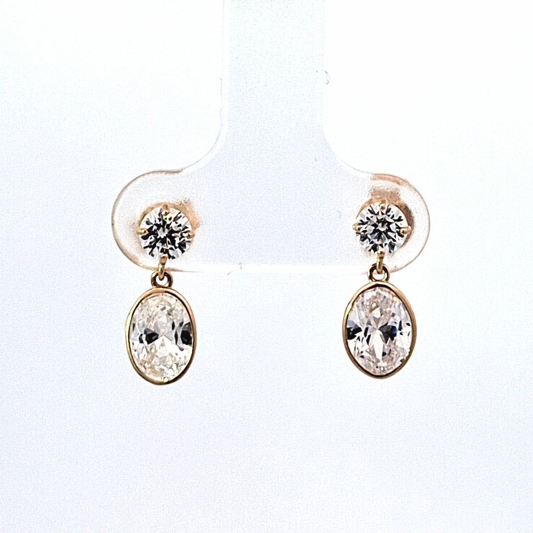 Gold earrings with clear gemstones on a white background