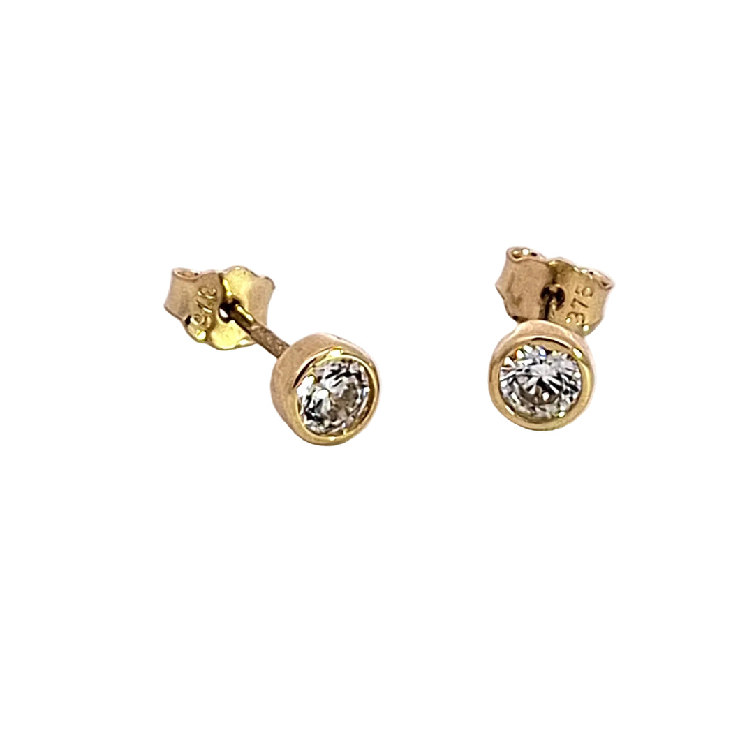 Gold stud earrings with clear gemstones on a white background