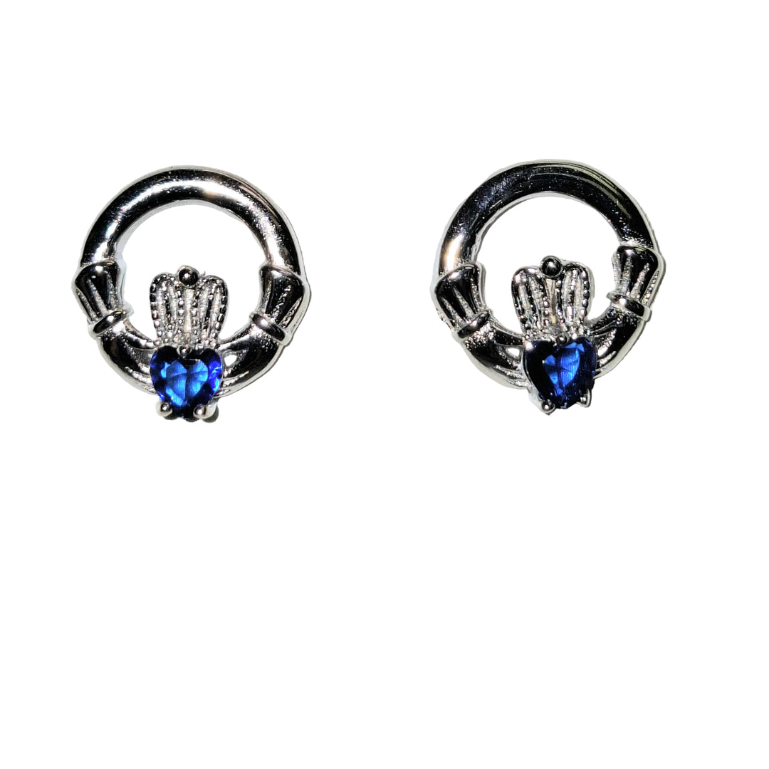 Pair of silver claddagh earrings with blue gemstones on a white background