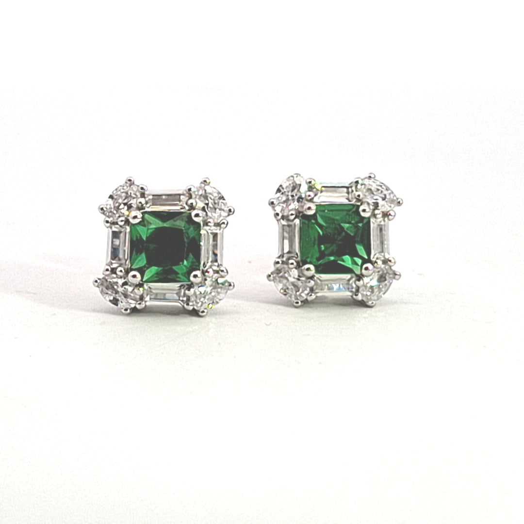 Pair of emerald green CZ gemstone earrings with silver accents on a white background