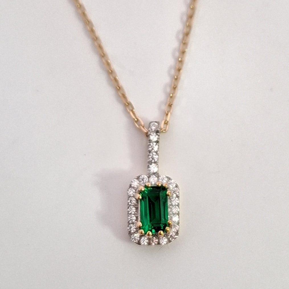 Emerald pendant necklace on a white background