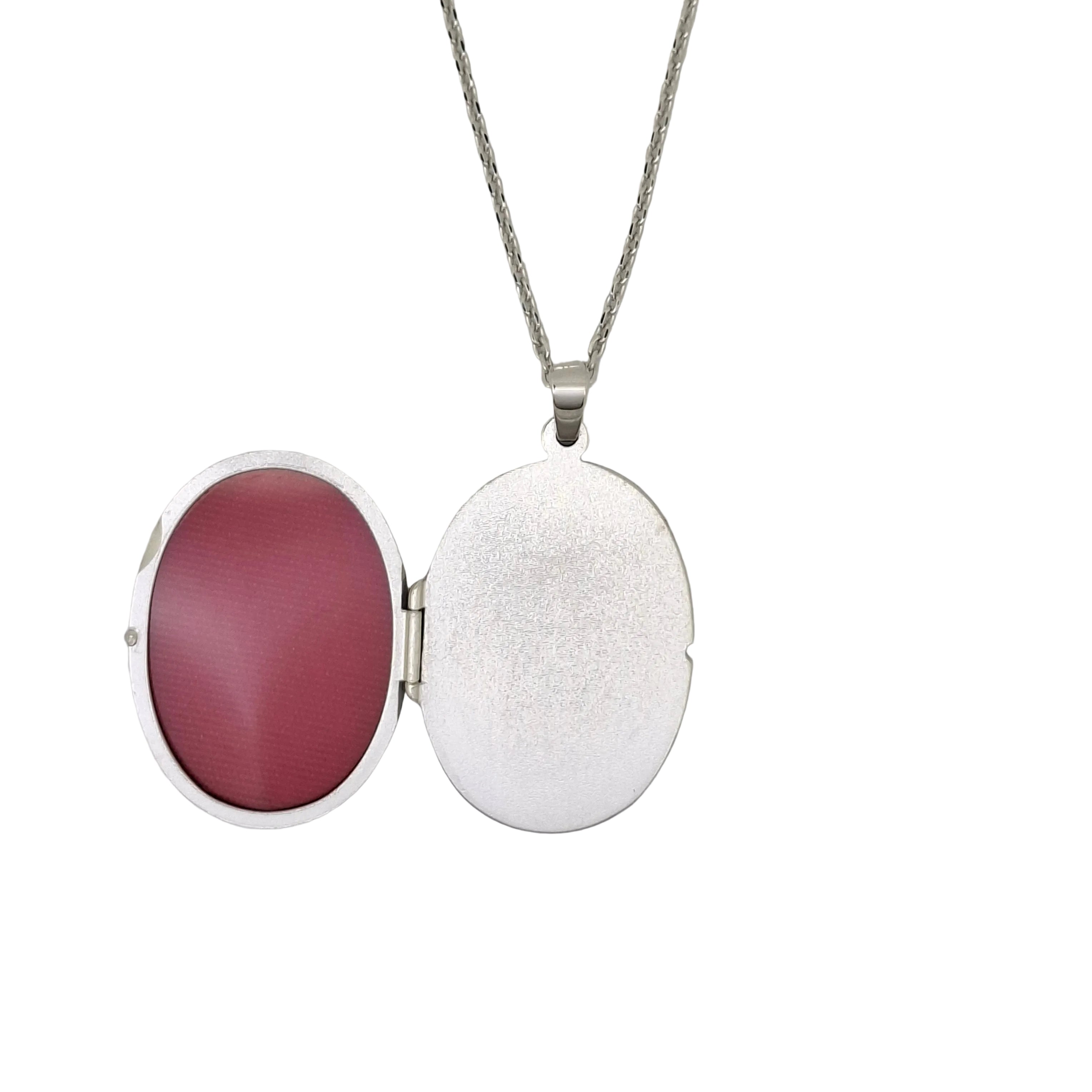Silver locket with a red interior on a white background